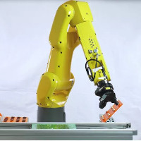 A Fanuc industrial robot assembling a printed circuit board